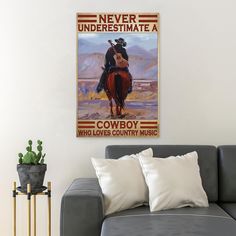 a living room with a couch and a poster on the wall above it that says never underestimate a cowboy who loves country music