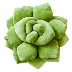 a green flower shaped pillow sitting on top of a white surface