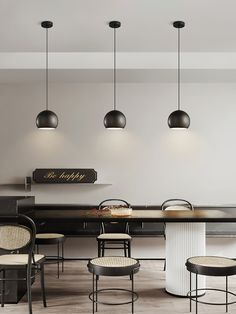 a dining room table with four chairs and three pendant lights hanging from it's ceiling