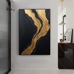 a black and gold art piece hanging on the wall in a white room with marble flooring