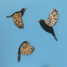 three black birds with gold designs on their wings