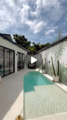 an outdoor swimming pool surrounded by white walls