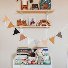 a shelf filled with books and toys on top of a wall