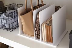 three purses are sitting on a shelf next to each other, with one bag in the middle