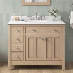 a bathroom with a sink, mirror and towels on the rack in front of it