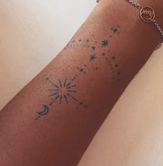 a woman's arm with a tattoo on it and a star in the sky