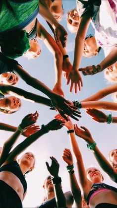 a group of people standing in a circle with their hands together