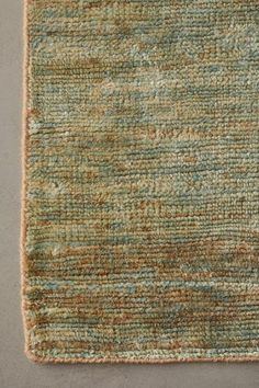 an area rug that has been made with various colors and textures, including blue, green,