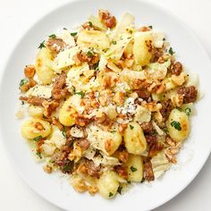 a white plate topped with pasta and meat