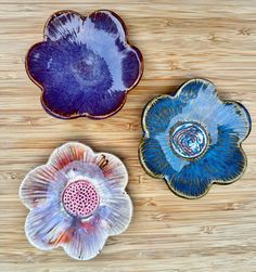 three decorative plates sitting on top of a wooden table