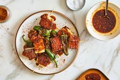 some food is sitting on a plate with toothpicks and sauces next to it