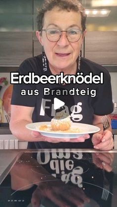 an older woman holding a plate with food on it in front of her and the words erdbeerknodel aus franettej