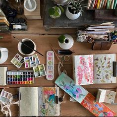 an assortment of art supplies on a wooden table