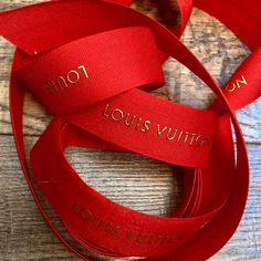 two red ribbons with the words louis vuitton and louis v written on them