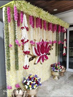 flowers are hanging from the side of a wall