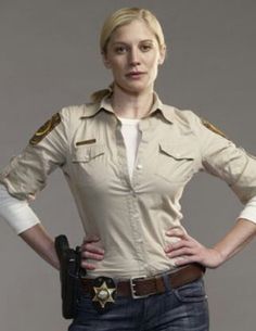 a woman in uniform standing with her hands on her hips and looking at the camera