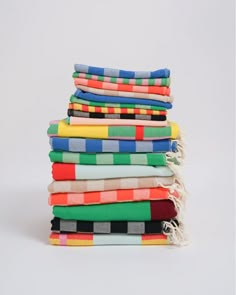 stack of multicolored towels folded on top of each other in different colors and patterns