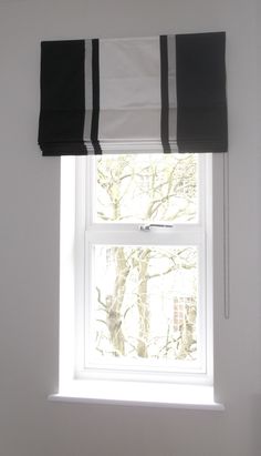 a window with black and white roman shades