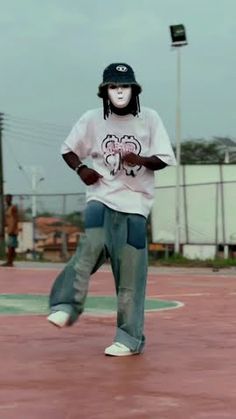 a person wearing a helmet and jeans is playing with a frisbee on a court