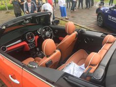 the interior of a sports car with people standing around