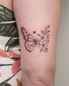 a woman's arm with a butterfly and flowers tattoo on it