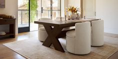 a dining room table with chairs and vases on top of it in front of a sliding glass door