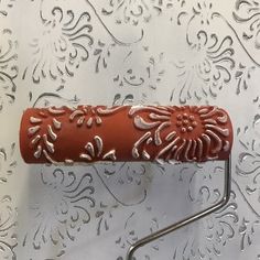 a metal rack with a red handle on top of a silver wallpapered surface