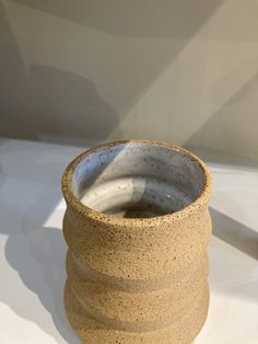 a brown vase sitting on top of a white table