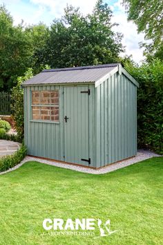 a garden shed with the words crane on it in front of some grass and trees