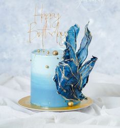 a blue and gold birthday cake on a plate