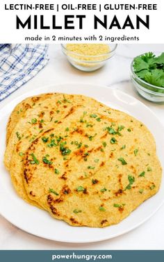 two flatbreads on a white plate with cilantro and parsley in the background