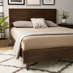 a bed sitting on top of a white rug next to a wooden headboard and foot board