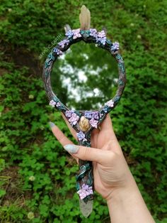 A hand sculpted handheld mirror. the mirror base is shimmering tree branches, with pastel pink, purple, and blue flowers throughout. There are also vines and several natural crystals throughout Fairy Altar, Aesthetic Sculpture, Mirror Sculpture, Crystal Mirror, Tiffany Stone, Tourmalated Quartz, Vera Cruz