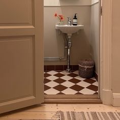 an open door leading to a bathroom with checkered flooring