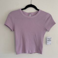 Women’s Light Purple Ribbed Cropped Baby Tee Size Small New With Tags Also Available In Dark Blue/Purple Color Casual Purple Ribbed Top, Casual Purple Crew Neck Crop Top, Purple Ribbed Stretch Top, Purple Stretch Ribbed Tops, Stretch Purple Ribbed Tops, Stretch Ribbed Purple Tops, Purple Ribbed Tops For Summer, Purple Ribbed Summer Tops, Summer Purple Ribbed Tops