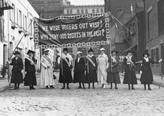 an old black and white photo of women holding flags in front of a sign that says we