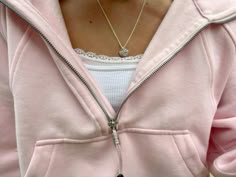 a woman wearing a pink hoodie holding a cell phone