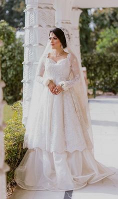 a woman in a wedding dress standing under a gazebo with her hands on her hips