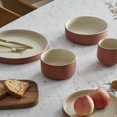 the table is set with plates, bowls and utensils for breakfast or dessert