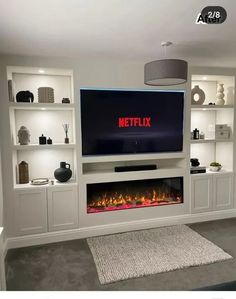 a flat screen tv mounted on a wall above a fire place in a living room