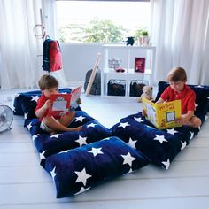 two young boys sitting on bean bags reading books