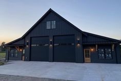 a black house with two garages and lights on