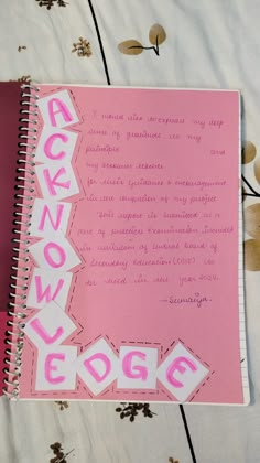 a pink notebook with the words acknow edge written in cursive writing