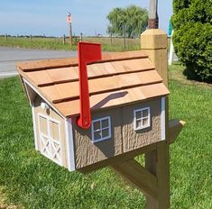 a wooden bird house with a red roof