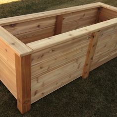 a wooden planter box sitting on top of grass