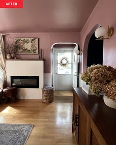 a living room filled with furniture and a fire place next to a doorway that leads into a hallway