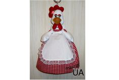 a stuffed chicken wearing a red and white dress hanging from a hook on a wall