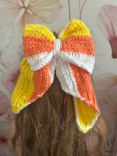 a close up of a child's hair wearing a knitted bow