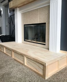 a living room with a fireplace and built - in shelves on the floor next to it