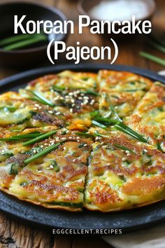 korean pancake pajeon on a plate with green onions and sesame seeds in the middle